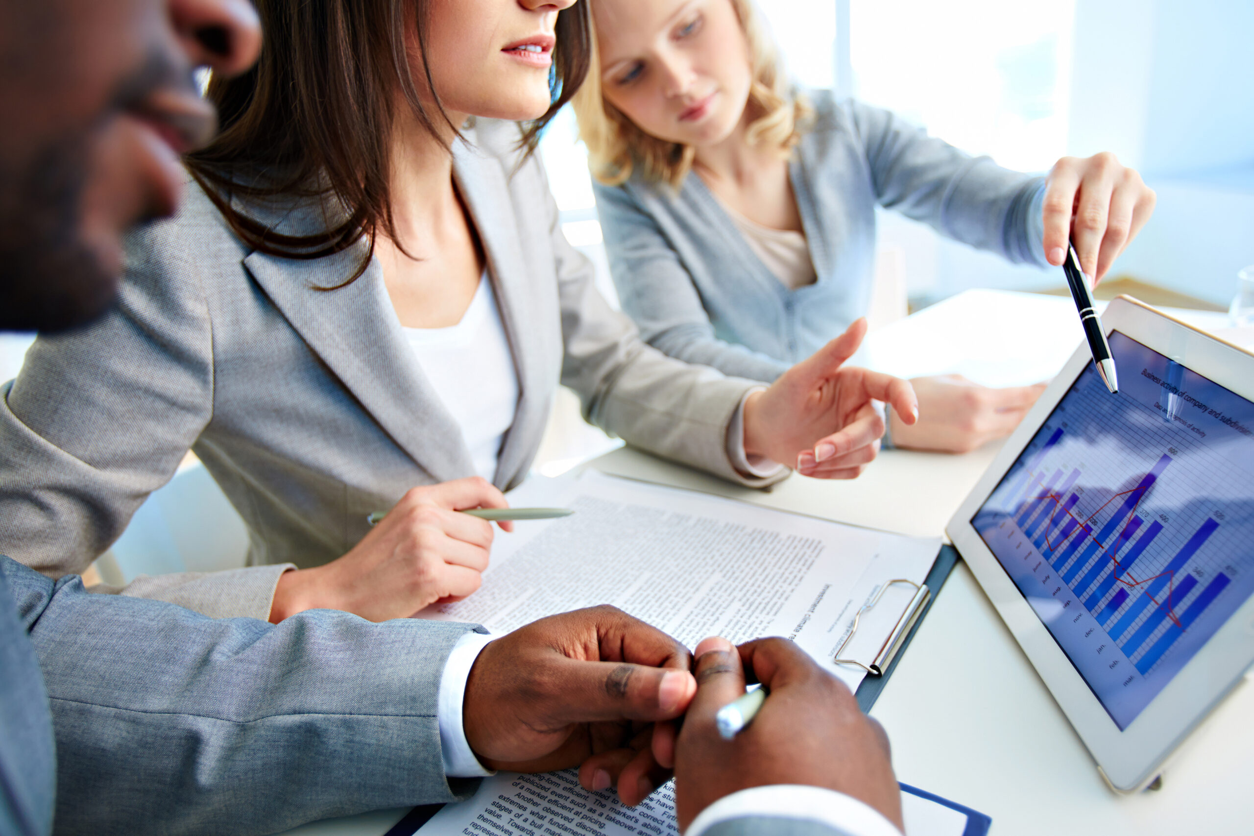 Close-up of young businesswomen discussing document in touchpad